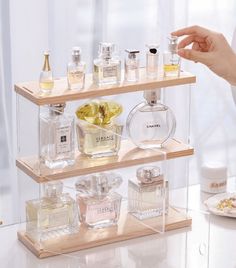 three tiered display case with perfume bottles on it