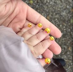 a person holding out their hand with smiley faces on it