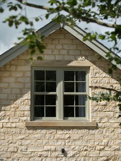 a bird sitting on the window sill of a brick building with trees in front of it