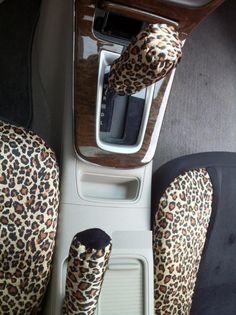 the interior of a vehicle with leopard print seats and steering wheel covers, including an automatic gear box