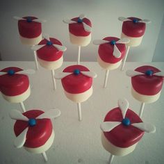 there are many red and white cake pops on the table