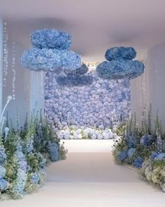 a white and blue floral display in the middle of a room with flowers on it