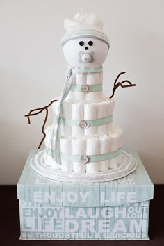 a baby shower cake made to look like a snowman on top of a pile of diapers