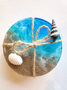 a blue glass plate with a seashell tied to it