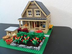 a lego house sitting on top of a table next to a potted planter