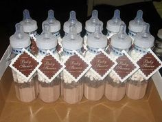 baby shower favors are arranged in bottles on a table with brown and white paper tags