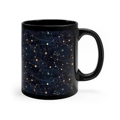 a black coffee mug with gold stars and the sky in it's bottom half