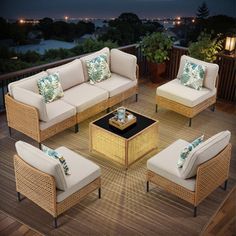 an outdoor living room with wicker furniture on a wooden deck at night, overlooking the city lights