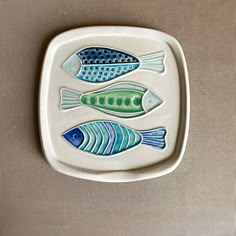 a plate with three fish painted on it