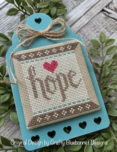 a cross stitch ornament with the word hope on it