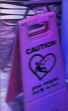 a pink caution sign sitting on top of a wooden bench next to a purple chair