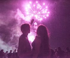 two people looking at fireworks in the sky