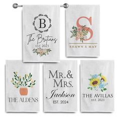 four personalized wedding towels hanging on a towel rack with monogrammed names and flowers