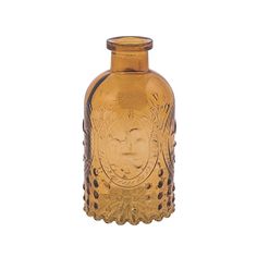 an old fashioned glass bottle with a face etched on the front and sides, sitting against a white background