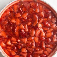 a bowl filled with strawberries sitting on top of a table