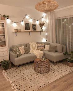 a living room filled with furniture and lights on the wall above it's windows