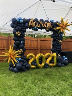 a balloon arch that says aaron with balloons and stars in the shape of numbers on it