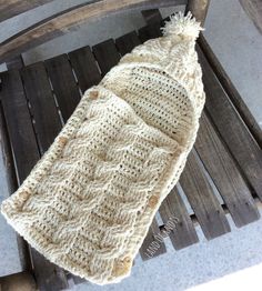 a knitted hat sitting on top of a wooden bench