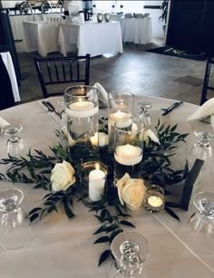 a table topped with lots of white flowers and candles