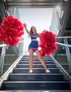 the cheerleader is posing on the stairs with her pom poms in hand