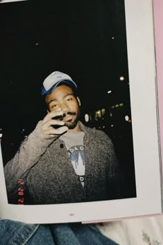 a man holding up a polaroid photo in front of his face