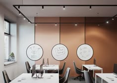 an empty office with desks and chairs in front of two large round whiteboards on the wall