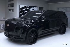 a black suv is parked in a showroom