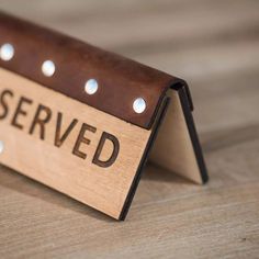 a wooden sign that says reserved on it with rivets and holes around the edges