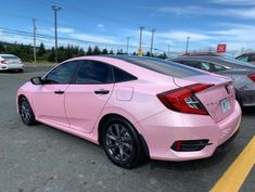 a pink car is parked in a parking lot