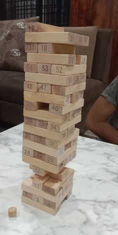 a stack of wooden blocks sitting on top of a white table next to a couch