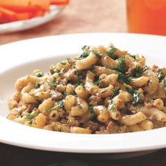 a white plate topped with pasta and meat