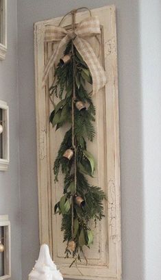 a christmas wreath is hung on the wall above a mantle with candles and other decorations