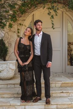 a man and woman standing on steps in front of a house