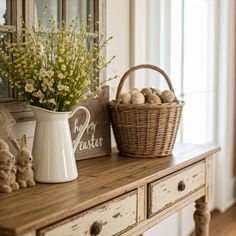 a white vase filled with flowers sitting on top of a wooden table next to a basket full of eggs