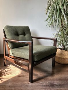 a green chair sitting next to a potted plant