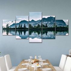 a dining room table with white chairs and a mountain range in the distance on it