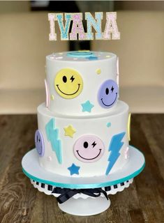 a three tiered cake decorated with smiley faces and the word i wanna on top