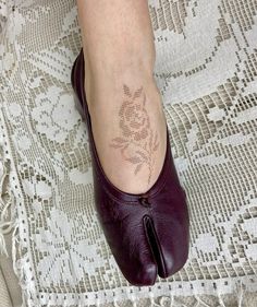 a woman's foot with a small tattoo on it