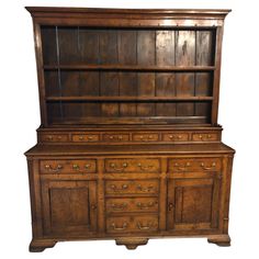 an old wooden dresser with drawers and cupboards on the top, against a white background