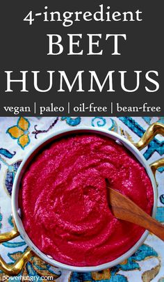 a bowl filled with beet hummus on top of a table