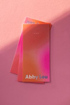 three sheets of pink and orange paper with the words abby louu on them