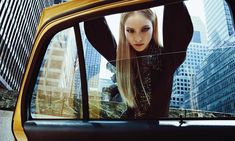 a woman standing in the window of a taxi