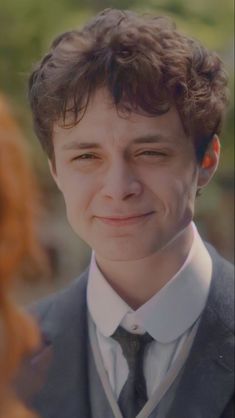 a close up of a person wearing a suit and tie