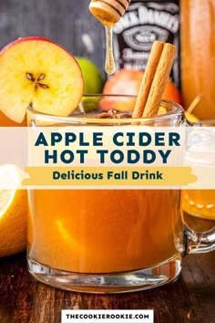 apple cider hot toddy in a glass mug with cinnamon sticks and apples