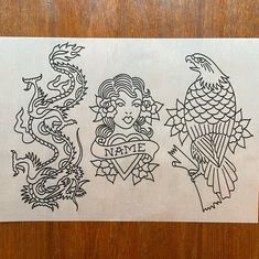 two tattoo designs on a piece of paper that is sitting on top of a wooden table