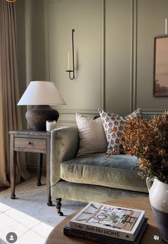 a living room filled with furniture and a lamp on top of a wooden coffee table