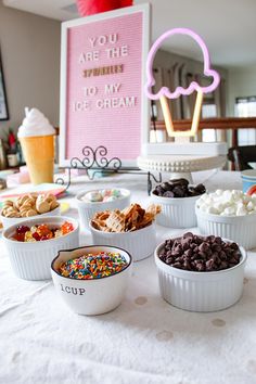 a table topped with bowls filled with different types of desserts and icecream