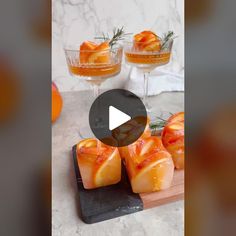 the video is showing how to make orange jellies in small glass bowls with rosemary garnishes