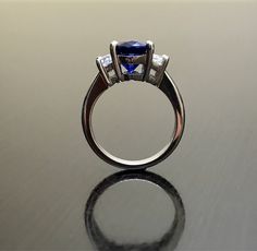 Dekara Designs Collection Metal- 90% Platinum, 10% Iridium. Stones- 1 Natural Untreated 3.88 Carat Oval Cut Ceylon Blue Sapphire. 2 Moon Cut Diamonds, F-G Color VS1 Clarity 0.77 total carats This ring is a size 6, but could be sized up or down a few sizes. This ring could be made in your specific size within 5-10 business days. Could take a little more time due to the ceylon sapphire being a rare stone. The sapphire may be a bit smaller or bigger. We can make the same design in a smaller or bigg Classic Royal Blue Round Sapphire Ring, Blue Tanzanite Promise Ring, Trillion Cut Tanzanite Rings For Wedding, Blue Three Stone Round Cut Diamond Ring, Blue Sapphire Ring With Three Stones, Classic Royal Blue Round Ring, Classic Blue Rings With Lab-created Sapphire, Blue Rings With Prong Setting For Promise, Classic Blue Lab-created Sapphire Rings