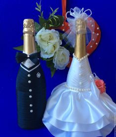 two wedding decorations made to look like champagne bottles and bride's dress with flowers